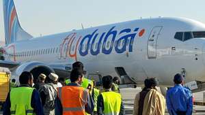 epa10976247 People stand next to a flydubai plane after it landed at Kabul airport in Kabul, Afghanistan, 15 November 2023. Flydubai resumed flights to Kabul International Airport after a two-year suspension, following the airline's October announcement to reinstate flights between the UAE and Kabul, signaling a positive step in restoring air connectivity.  EPA/SAMIULLHA POPALZAI