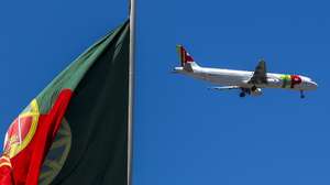 Um avião da TAP voa sobre uma bandeira de Portugal, no Parque Eduardo VII, em Lisboa, 10 de julho de 2023. JOSÉ SENA GOULÃO/LUSA
