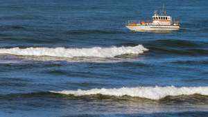 Um barco salva-vidas participa nas buscas dos três tripulantes de uma embarcação desaparecida na sexta-feira ao largo na Nazaré, na Praia do Pedrogão em Leiria. PAULO CUNHA/LUSA