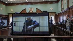 epa09971349 Russian opposition leader Alexei Navalny is shown on a monitor screen via video link from the penal colony No. 2 (IK-2) in Pokrov in Vladimir region, during a hearing of an appeal against Lefortovsky court sentence at the Moscow city court in Moscow, Russia, 24 May 2022. The Lefortovsky court sentenced politician Alexei Navalny to nine years in a strict regime colony and a fine of 1.2 million rubles for large-scale fraud and insulting the court. The Moscow city court upholded Navalny's conviction.  EPA/YURI KOCHETKOV