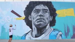 epa10351885 A fan of Argentina takes a picture of a mural depicting Argentinian soccer legend Diego Armando Maradona outside the Khalifa International Stadium in Doha, Qatar, 06 December 2022. Argentina will face the Netherlands in their FIFA World Cup 2022 quarter final soccer match on 09 December 2022.  EPA/ABIR SULTAN