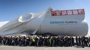 epa08408493 (FILE) - Workers watch the uncovering of an engine nacelle during the inauguration ceremony of the new offshore wind engine nacelle plant of Siemens Gamesa in Cuxhaven, northern Germany, 05 June 2018 (reissued 07 May 2020). Siemens AG, a German multinational conglomerate company headquartered in Munich and the largest industrial manufacturing company in Europe, releases the second quarter results for fiscal year 2020 on 08 May 2020.  EPA/FOCKE STRANGMANN
