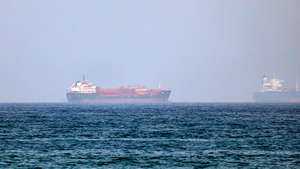 epa13125320 Cargo vessels are seen at one end of the Strait of Hormuz near the coast of Dibba Al Fujairah, United Arab Emirates, 21 July 2026.  EPA/STRINGER
