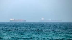 epa13125319 Cargo vessels are seen at one end of the Strait of Hormuz near the coast of Dibba Al Fujairah, United Arab Emirates, 21 July 2026.  EPA/STRINGER