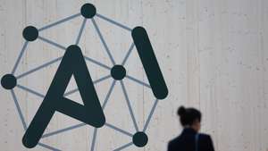 epa11886490 A person walks past the logo of the Artificial Intelligence (AI) Action Summit at the Grand Palais in Paris, France, 10 February 2025. The summit takes place from 10 to 11 February.  EPA/MOHAMMED BADRA