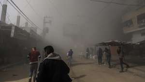 epa11736326 Palestinians take cover as smoke rises following an Israeli airstrike on the Al Farouq Mosque in the Al Nuseirat refugee camp, central Gaza Strip, 23 November 2024. More than 44,000 Palestinians, including over 13,000 children, have been killed according to the Palestinian Ministry of Health and over 1,400 Israelis have been killed according to the Israeli army, since Hamas militants launched an attack against Israel from the Gaza Strip on 07 October 2023, and the Israeli operations in Gaza and the West Bank which followed it.  EPA/MOHAMMED SABER