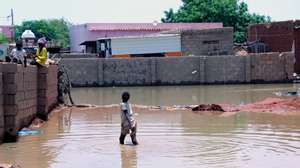 epa08633613 People stand at an inundated area after flooding of the Nile River at al-Kalakla area, south of Khartoum, Sudan, 29 August 2020. According to media reports, at least 86 people reportedly died due to record flood level of the Nile River that also damaged thousands of houses.  EPA/MOHAMMED ABU OBAID