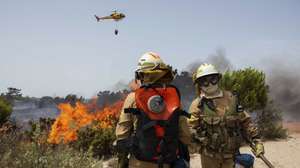Elementos da Unidade de Emergência de Proteção e Socorro (UEPS) durante o combate ao incêndio que lavra na zona da Quinta do Lago, em Almancil, Faro, 13 de julho de 2022. Dezasseis dos 18 distritos de Portugal continental estão hoje sob aviso vermelho, o mais grave, devido ao tempo quente, com mais de uma centena de concelhos em perigo máximo de incêndio rural. DUARTE DRAGO/LUSA