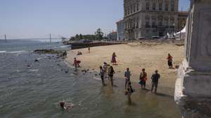 Turistas refrescam-se na água do Rio Tejo
