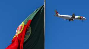 Um avião da TAP voa sobre uma bandeira de Portugal, no Parque Eduardo VII, em Lisboa, 10 de julho de 2023. JOSÉ SENA GOULÃO/LUSA