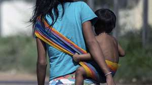 epa10443384 An indigenous Yanomami woman and a baby in a rural area near the Casa de Saude Indigena (CASAI), in Boa Vista, in the Amazonian state of Roraima, Brazil, 01 February 2023. Hundreds of Yanomami are in the capital of the state of Roraima due to the health crisis that thrives on their lands due to the presence of illegal mining. The Brazilian government decreed a state of health emergency on Yanomami land ten days ago, when President Lula visited the area to verify the situation of abandonment in which the indigenous people of that region live. About 21,000 Yanomami, out of a population of 27,000, have been infected with malaria, many suffer from heavy metal poisoning used by illegal miners, and a large number suffer from malnutrition.  EPA/Raphael Alves