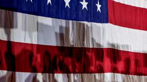 epa11109422 Shadows of supporters on a US flag as Republican US presidential candidate Nikki Haley speaks during a campaign event at Mauldin High School in Mauldin, South Carolina, USA, 27 January 2024. Haley, the former South Carolina governor, is running against former US President Donald Trump in the South Carolina Republican Presidential Primary 24 February 2024.  EPA/ERIK S. LESSER