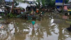 epa11726695 A villager wades in floodwater in the typhoon-hit municipality of Baler, Aurora province, Philippines, 18 November 2024. Local government units in typhoon Man-yi’s path from Bicol region to Luzon region conducted pre-emptive evacuation of citizens to safeguard against floods and strong winds.  EPA/FRANCIS R. MALASIG