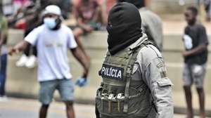 Um elemento da Polícia controla os manifestantes que cortaram hoje por completo os acessos à portagem de Maputo, principal entrada e saída da capital moçambicana, com barricadas e veículos pesados atravessados, contestando a retoma de cobrança, após semanas de suspensão devido aos protestos pós-eleitorais, Moçambique, 23 de janeiro de 2025. LUÍSA NHANTUMBO/LUSA