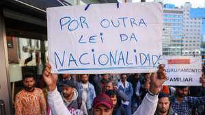epa12015245 A protester holds a banner 'In defence of another nationality law' during a protest against the discrimination and lack of answers from Agency for Integration, Migration and Asylum (AIMA) in Lisbon, Portugal, 07 April 2025. The initiative, supported by Portugal’s largest immigrant association, Solidariedade Imigrante, reflects the concerns of immigrants over recent legal reforms that abolished the ‘expression of interest’ — a legal resource that allowed the legalisation of foreigners only with a tourist visa.  EPA/MIGUEL A. LOPES
