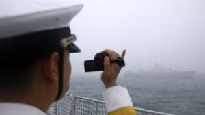 epa07523339 Chinese navy personnel takes video to Vietnamese frigate Dinh Tien Hoang (HQ-011) during the Navy parade to celebrate the 70th anniversary of the Chinese People's Liberation Army (PLA) Navy in Qingdao, China's Shandong province, 23 April 2019.  EPA/WU HONG