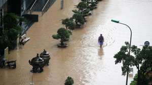 epa12436145 A man wades through a flooded street in Hanoi, Vietnam, 07 October 2025. Torrential rains triggered by Typhoon Matmo caused flooding in Hanoi’s streets on 07 October.  EPA/LUONG THAI LINH