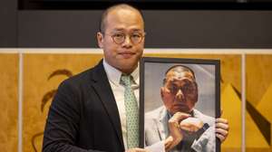 epa11903371 Sebastien Lai, son of imprisoned Hong Kong media publisher Jimmy Lai, shows a picture of his father, during a preview of the Geneva Summit for Human Rights and Democracy at the European headquarters of the United Nations in Geneva, Switzerland, 17 February 2025. The summit will take place on 18 February 2025.  EPA/SALVATORE DI NOLFI