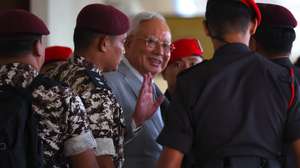 epa12608192 Former Malaysia Prime Minister Najib Razak (C) is escorted by Royal Malaysian Police officers as he arrives at Kuala Lumpur High Court in Kuala Lumpur, Malaysia, 22 December 2025. The Kuala Lumpur High Court will decide today whether Malaysia former prime minister Najib Razak may serve the remainder of his six-year jail term under house arrest.  EPA/FAZRY ISMAIL