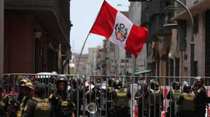 epa12750957 A person holds a Peruvian flag during a demonstration against interim president Jose Jeri in front of the Peruvian Congress in Lima, Peru, 17 February 2026. The Peruvian Congress began a special session to discuss seven motions of censure filed against Jeri, which could lead to the eighth presidential change in the Andean country in nearly a decade of political instability.  EPA/Paolo Aguilar