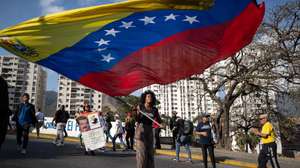 epaselect epa12793160 A person waves a Venezuelan flag during a march in Caracas, Venezuela, 03 March 2026. Hundreds of Chavistas march to demand the release of Nicolas Maduro and his wife Cilia Flores two months after their capture by US military forces following an attack on Caracas and three nearby regions.  EPA/Ronald Peña R