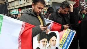 epa12811441 A man holds a poster of the late Iranian supreme leader Ayatollah Ali Khamenei during a mass funeral for the Iran's Revolutionary Guards Corps (IRGC) commanders, army commanders and other victims who were killed during the Iran-US and Israel war in Tehran, Iran, 11 March 2026. A joint Israeli and US military operation continues to target multiple locations across Iran since the early hours of 28 February 2026.  EPA/ABEDIN TAHERKENAREH