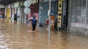 Uma popular caminha por uma rua inundada devido às chuvas na cidade de Maputo, Moçambique, 12 de março de 2026. A cidade de Maputo regista desde a manhã de hoje novas cheias, que condicionam a circulação em várias zonas da capital moçambicana, devido às fortes chuvas, pela segunda vez em menos de uma semana. (ACOMPANHA TEXTO). LINA CEBOLA/LUSA