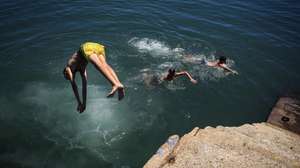 Rapazes mergulham no rio Douro no Porto, 1 de julho de 2026.O tempo quente que afeta Portugal dará origem a uma onda de calor que se prolongará por oito a 10 dias e atingirá praticamente todo o país, estimou hoje o Instituto Português do Mar e da Atmosfera (IPMA).  JOSÉ COELHO/LUSA