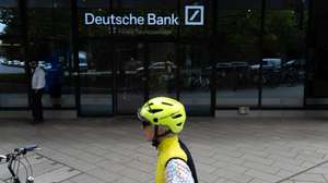 epa13126208 A cyclist parks their bicycle outside the Deutsche Bank central headquarters in Frankfurt, Germany, 22 July 2026. Germany's largest commercial bank, Deutsche Bank, confirmed that its headquarters were searched during an investigation led by the Duesseldorf Public Prosecutor's Office regarding potentially illegal cum-cum transactions involving Postbank between 2008 and 2010.  EPA/MATIAS BASUALDO