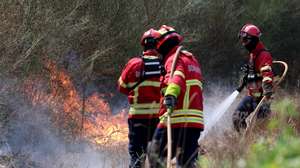 Bombeiros combatem o incêndio florestal que deflagrou ao final da tarde de segunda-feira em Rebordões, no concelho de Santo Tirso, em Burgães, 18 de agosto de 2026. ESTELA SILVA/LUSA