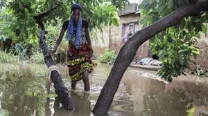 A woman walk by a flooded area following rains since 07 of February in Maputo, Mozambique, 09 February 2023. About 2,400 families were left homeless, and dozens of houses flooded in the Mozambican capital. LUISA NHANTUMBO/LUSA