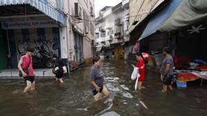 epa13265924 Residents wade through floodwater after the prolonged downpour at a flooded community in Bangkok, Thailand, 27 September 2026. All 50 districts in Bangkok have been declared flood disaster zones following the prolonged heavy rain that caused flooding across the capital.  EPA/RUNGROJ YONGRIT