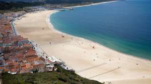 Sem sol e com poucos banhistas, a época balnear arrancou hoje com mais gente na marginal e nas esplanadas do que na praia da Nazaré, onde não falta espaço para cumprir distâncias de segurança, Nazaré, Leiria, 6 de junho de 2020. Com algumas nuvens a toldar o sol e a tornar a praia menos convidativa, era na marginal da Nazaré que manhã cedo se concentrava o movimento, com passeantes e atletas a cruzarem-se no passeio largo. PAULO CUNHA /LUSA