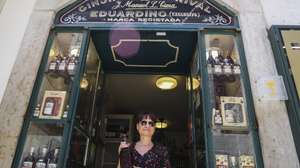 Uma turista turca posa para a fotografia com uma garrafa de ginjinha na porta de entrada da histórica loja "Ginjinha sem Rival", nas Portas de Santo Antão, em Lisboa, 25 de junho de 2025. A histórica loja Ginjinha Sem Rival, instalada na zona histórica de Lisboa desde 1890, tem ordem para encerrar portas já no final deste mês, mas o gerente promete “lutar até ao fim”, nem que seja nos tribunais. (ACOMPANHA TEXTO DA LUSA DA LUSA DO DIA 27 DE JUNHO DE 2025). TIAGO PETINGA/LUSA