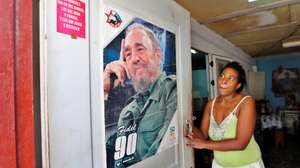 epa09494502 A woman observes a poster with the image of the historical leader of the Cuban revolution Fidel Castro at the door of her house, in Havana, Cuba, 28 September 2021. The Cuban Government commemorates on 28 September the 61st anniversary of the largest mass organization in the country. The CDR (Committees for the Defense of the Revolution) were born in 1960 with the objective of maintaining control and collective surveillance of everything that could destabilize the Cuban political system after the revolution.  EPA/Ernesto Mastrascusa