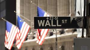 epa08839701 A sign for Wall Street in front of the New York Stock Exchange in New York, New York, USA, 24 November 2020. The Dow Jones industrial average passed 30,000 points today for the first time in history.  EPA/JUSTIN LANE
