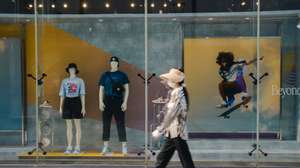 epa10790164 A woman walks by in front of the shop window of a clothing store in Beijing, China, 08 August 2023. China's trade surplus dropped to 80.6 billion US dollar (73.36 billion Euro) in July 2023, from 102.7 billion US dollar (93.47 billion euro) in the same period the prior year, as exports fell more than imports amid demand weakened from home and abroad, the General Administration of Customs reported.  EPA/WU HAO