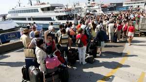 epa000482586 Numerous tourists wait in line at Beverello wharf, Saturday 16 July 2005, to embark boats for the islands of the gulf of Naples, like Goats, Ischia and Procida, which are popular destinations for the tourists of Italy's Campania region.  EPA/CIRO FUSCO