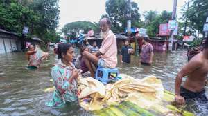 epa11559877 People use a raft to go to a safe place after a widespread flash flood in Feni district, Bangladesh, 22 August 2024. According to the Ministry of Disaster Management and Relief during a press conference at the secretariat, at least two people have died in flash floods across the country.  EPA/STR