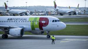 Um trabalhador de placa dá indicações a um piloto num avião da TAP, no Aeroporto Humberto Delgado, em Lisboa, 15 de abril de 2025.  JOSÉ SENA GOULÃO/LUSA
