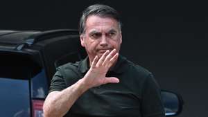 epa12377399 Brazilian former President Jair Bolsonaro waves upon arriving at his home in Brasilia, Brazil, 14 September 2025. Bolsonaro returned to house arrest at his residence in Brasilia hours after being admitted to a private hospital for surgery. The former head of state was sentenced by the Supreme Court to 27 years and three months in prison for conspiring against the democratic order following his defeat in the 2022 elections against current President Luiz Inacio Lula da Silva.  EPA/ANDRE BORGES