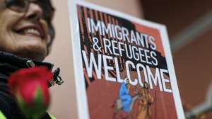 epaselect epa12689553 An activist holds a sign that reads 'Immigrants and refugees welcome' during a procession and prayer service in solidarity with migrants outside the Miami Immigration Court in Miami, Florida, USA, 28 January 2026. According to the organizers, the event comes amid heightened fear and uncertainty for immigrant communities and to affirm the Church's commitment to human dignity, regardless of immigration status.  EPA/CRISTOBAL HERRERA-ULASHKEVICH
