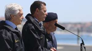 O primeiro-ministro, Luís Montenegro (C), ladeado pelo ministro da Defesa, Nuno Melo (E), discursa durante o acompanhamento das operações do navio-patrulha oceânico NRP Setúbal da Marinha Portuguesa ao largo de Cascais, 12 de agosto de 2026. TIAGO PETINGA/LUSA
