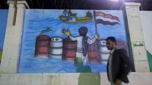 epa13187622 A person passes a mural depicting a Houthi fighter holding a Yemeni flag while stopping US and Israeli ships, in Sana'a, Yemen, 23 August 2026. Yemen's prolonged conflict has escalated over the past month, with the Houthis stepping up missile and drone strikes on Saudi-backed government positions, targets in neighboring Saudi Arabia, and ships in the Red Sea.  EPA/YAHYA ARHAB