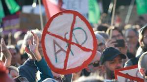 epa13220401 A participant holds a placard that resembles a road sign and shows a crossed out AfD during a rally at the Brandenburg Gate in Berlin, Germany, 07 September 2026. The protest was scheduled a day after the far-right Alternative for Germany party (AfD) won the election in the regional state of Saxony Anhalt by a wide margin.  EPA/CLEMENS BILAN