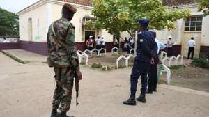 Forças de segurança observam os preparativos para a abertura das mesas de voto para as eleições presidenciais numa secção de voto, São Tomé, 19 de julho de 2026. NUNO VEIGA/LUSA