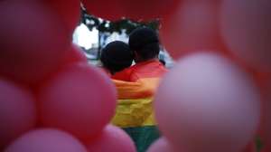 epa07683015 Seen through a balloon sculpture, a couple poses for a photograph with the rainbow flag draped over their shoulders during the Pink Dot event held at the Speaker&#039;s Corner in Hong Lim Park, Singapore, 29 June 2019. The annual Pink Dot event is the closest thing Singapore has to a gay pride parade which promotes an acceptance of the lesbian, gay, bisexual and transgender (LGBT) community and theme &#039;Standing Against Discrimination&#039;.  EPA/WALLACE WOON