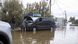epa13303967 A man attempts to repair his car following severe weather in Rhodes, Greece, 14 October 2026. Heavy rainfall, thunderstorms and gale-force winds have caused flooding and traffic disruptions across several parts of Greece. According to the Athens-Macedonia News Agency (AMNA), Coast Guard personnel recovered the body of a man whose car was swept into the sea at Stegna Beach in Archangelos, Rhodes.  EPA/LEFTERIS DAMIANIDIS