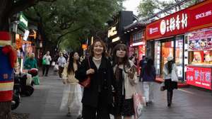 epa13321827 People walk on a street in a touristic area in Beijing, China, 22 October 2026.  EPA/JESSICA LEE