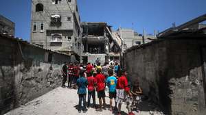 epa11419506 Palestinian children look at Civil Defense officers and civilians searching for missing people under the rubble of a destroyed house following an Israeli air strike, at al-Nuseirat refugee camp, southern Gaza Strip, 18 June 2024. More than 37,000 Palestinians and over 1,400 Israelis have been killed, according to the Palestinian Health Ministry and the Israel Defense Forces (IDF), since Hamas militants launched an attack against Israel from the Gaza Strip on 07 October 2023, and the Israeli operations in Gaza and the West Bank which followed it.  EPA/MOHAMMED SABER